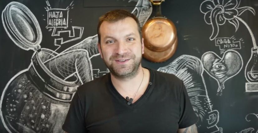 O 'chef' junto a uma parede da cozinha de casa, decorada por 3 amigos: um designer gráfico, um artista plástico e o seu tatuador.